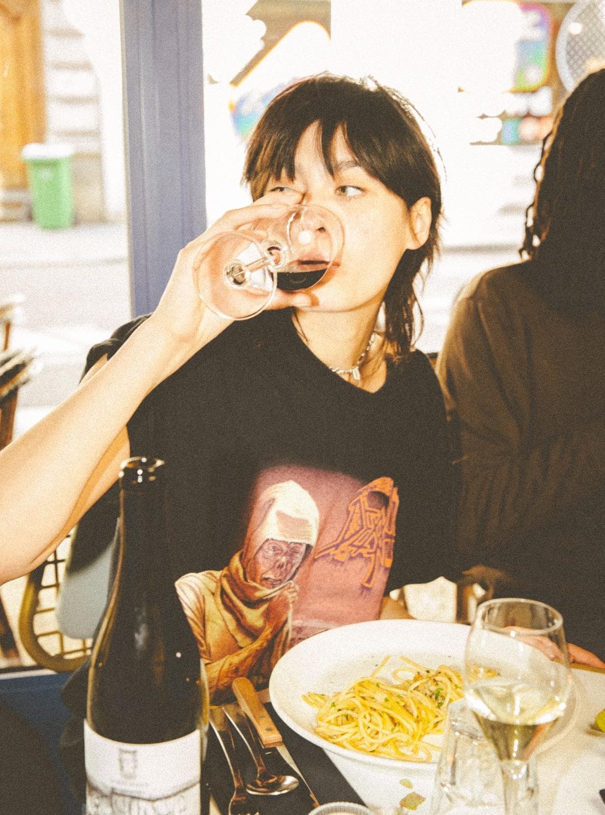 Femme buvant du vin avec des pâtes