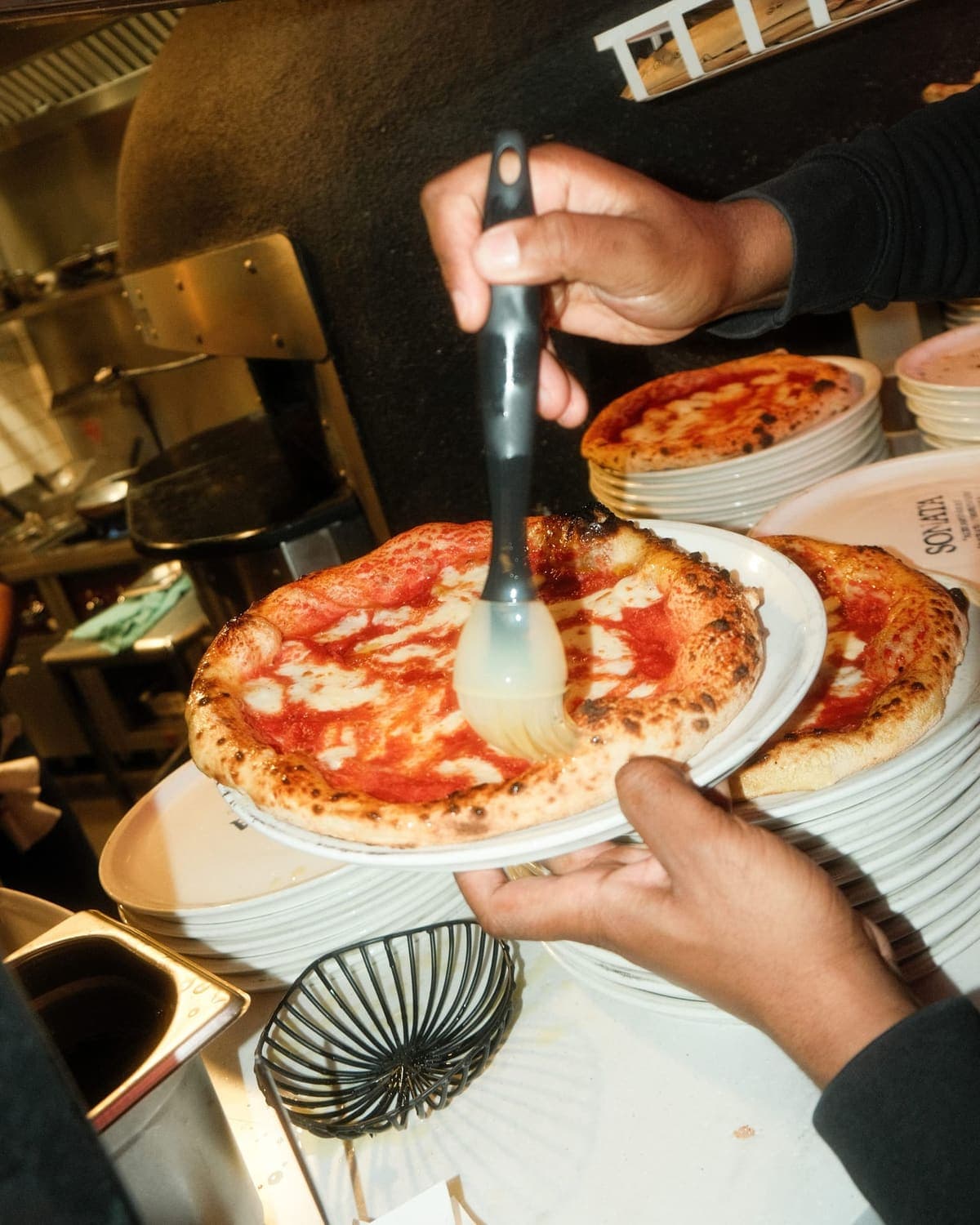 Mains découpant pizza